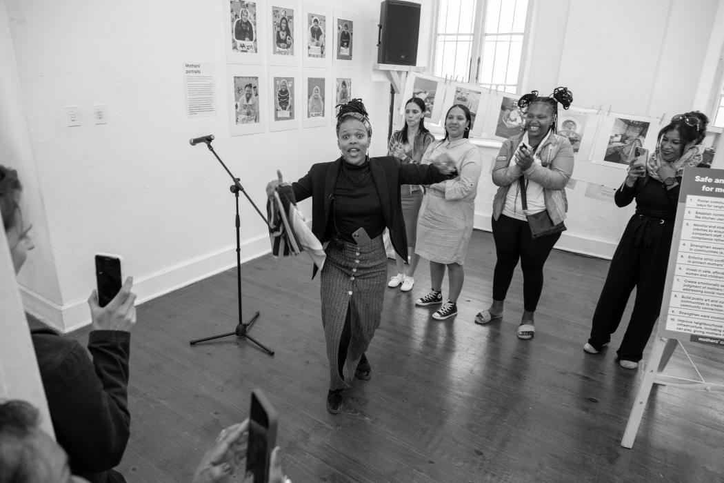 one person dancing, group of four people in background clapping and smiling