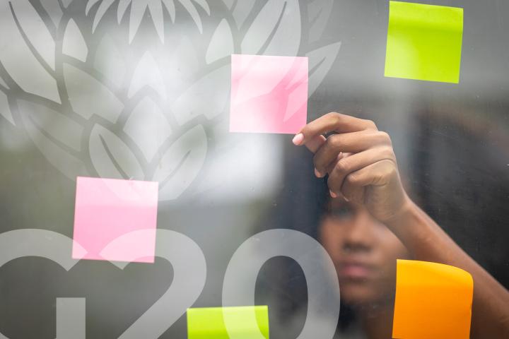 Woman standing behind a glass door, looking at looking at sticky notes attached to the door