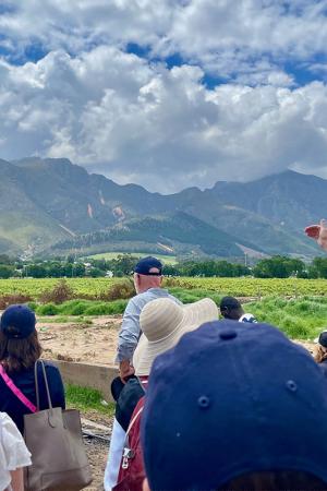 Group of people standing in green field, mountains in the background