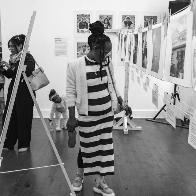 A visitor is taking in the powerful images and stories shared by mothers.