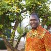 Edwin Muchapondwa smiling with a tree in the background
