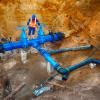 Technical expert underground at gate valve on 500mm drink water pipes joined with new black waga multi joint members into old pipeline system. Stock image